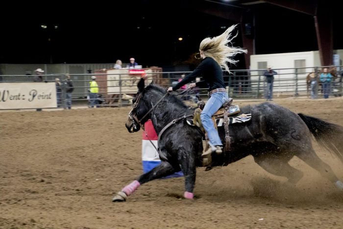 Blonde girl on horse at barrel races
